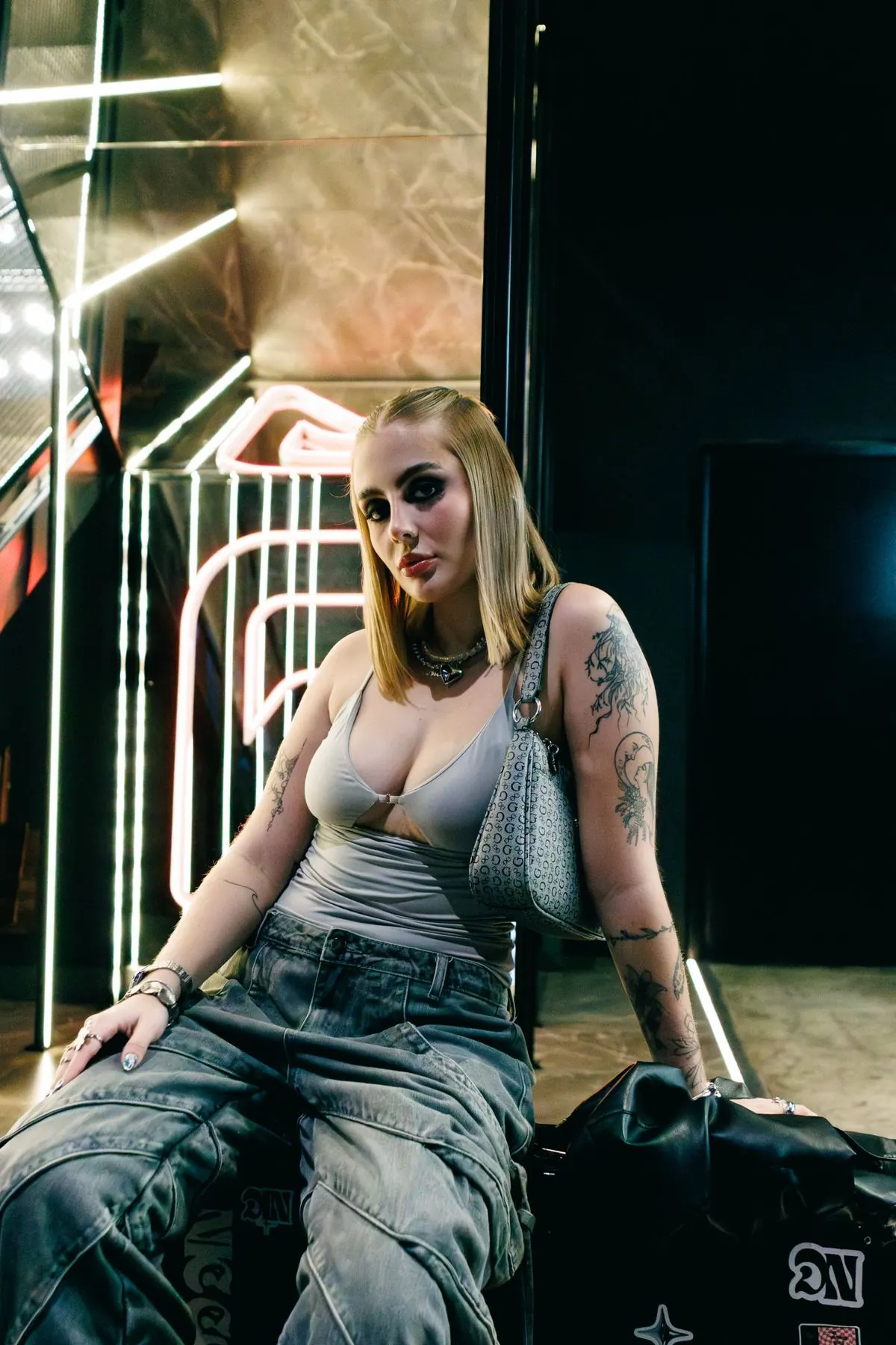 DJ sentada num cenário com luzes de neon